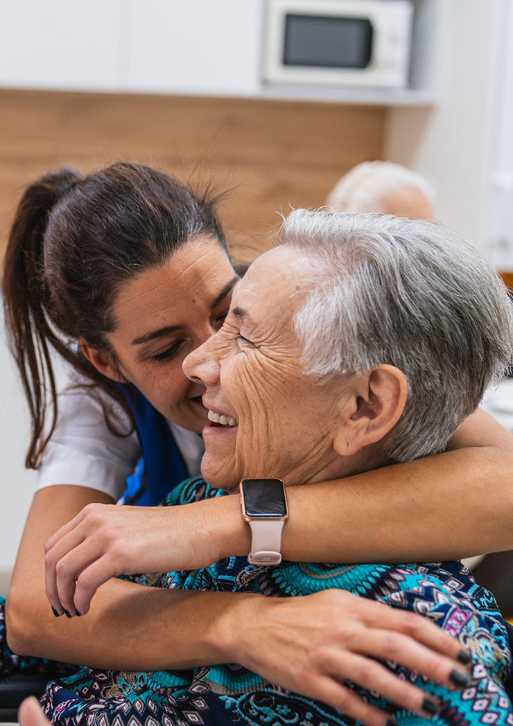 A caring nurse embracing an elderly woman in a nursing home.