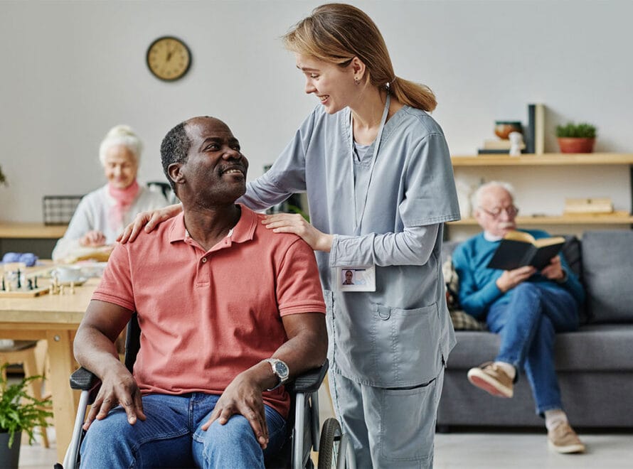 A nursing home caregiver with an elderly man.